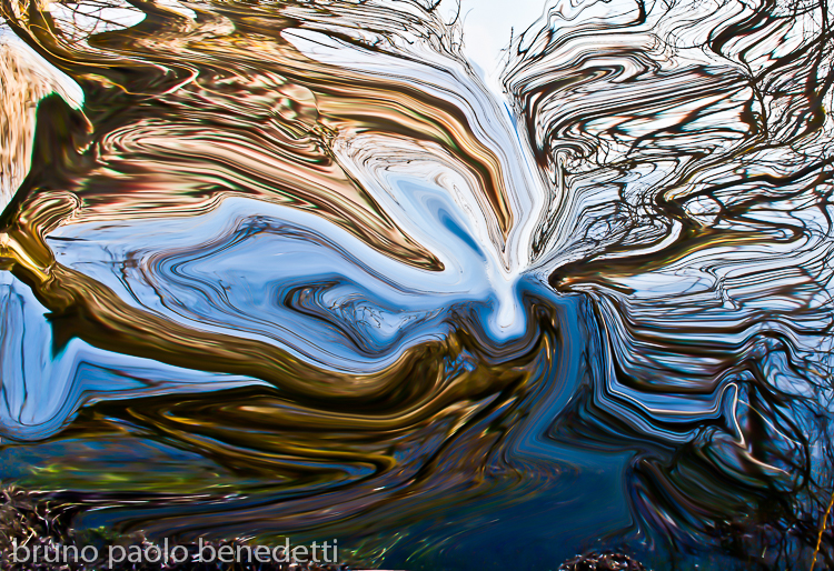 blue water with fluid shapes and light reflections in winter