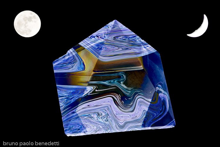 a mottled blue crystal pyramid floating in black space