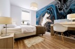 blue mural print on bedroom wall with blue dominant color with shades and fluid floating light shape